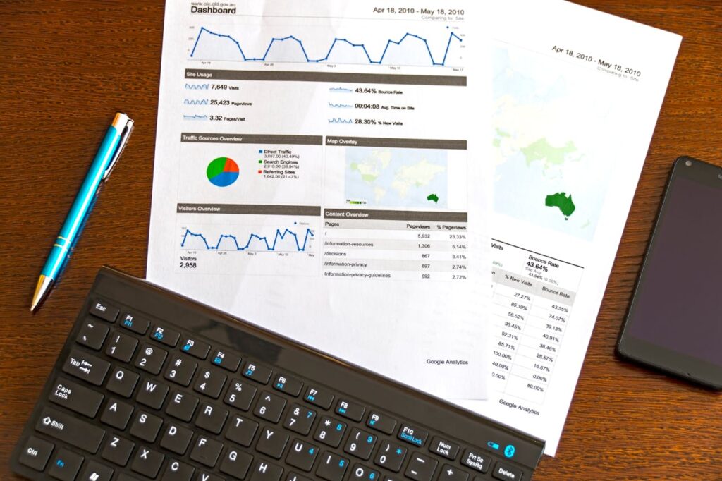 Solutions Flatlay of a business analytics report, keyboard, pen, and smartphone on a wooden desk.